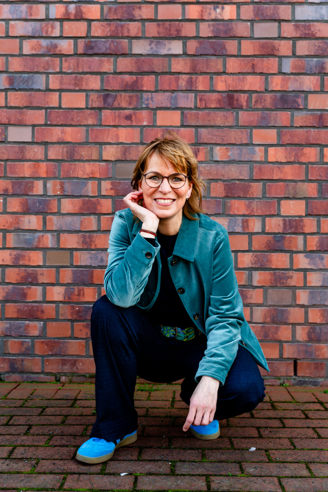 Professionelles Portrait einer Frau vor urbanem Hintergrund, aufgenommen für eine Künstler Sedcard.